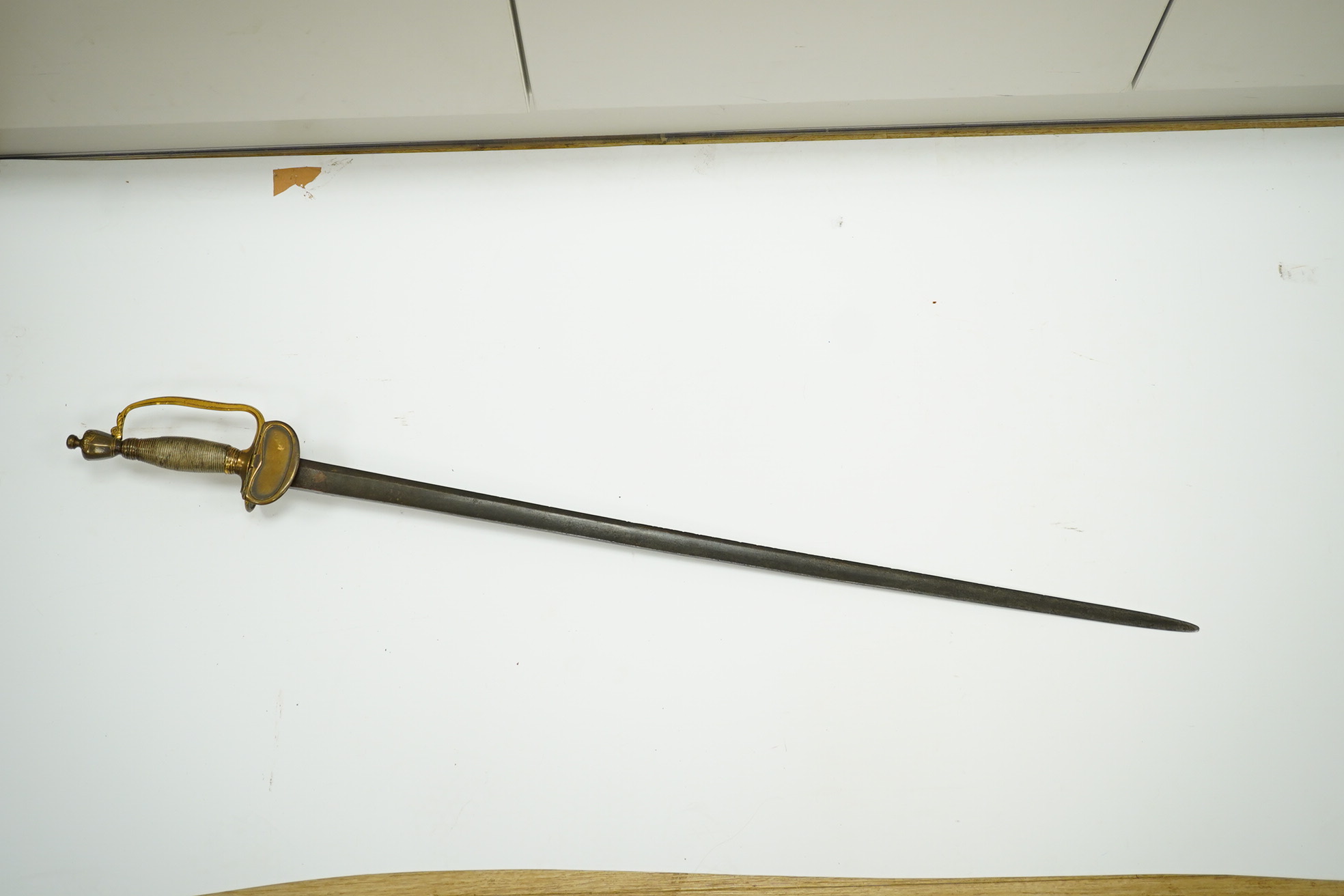 A 1796 pattern infantry officer's sword with regulation single edge blade, hilt with traces of gilding. Condition - fair, grip covering and quillon incomplete.